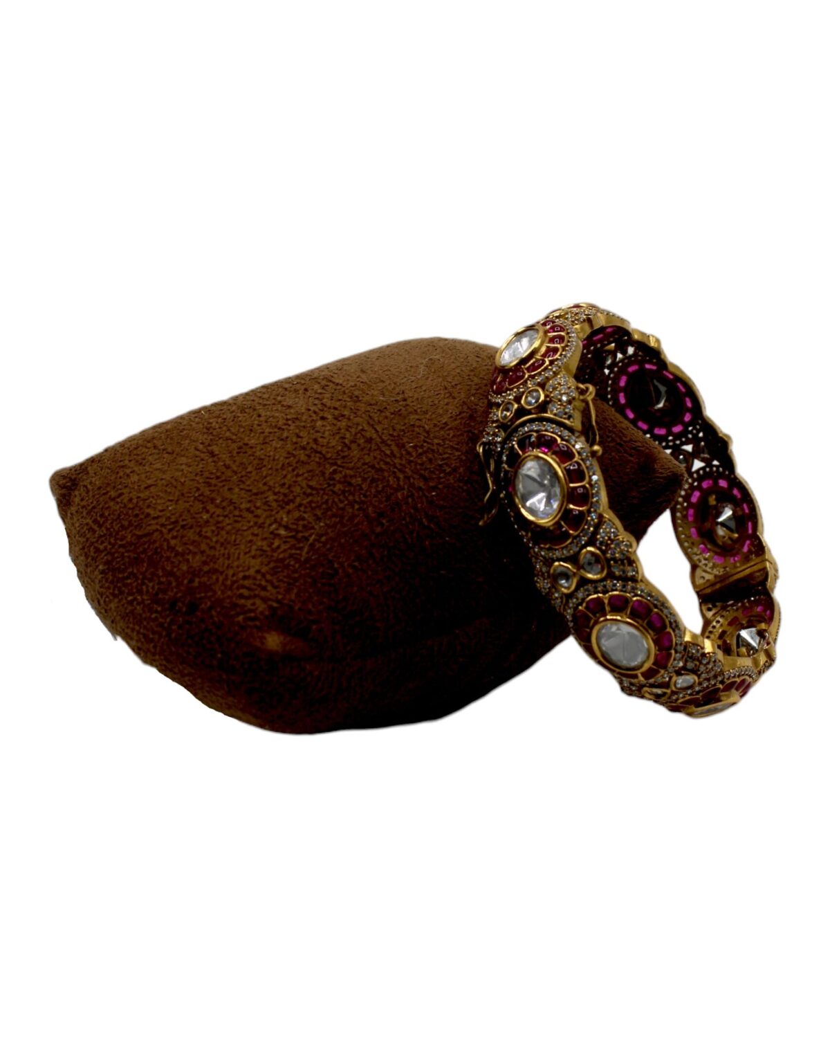 Elegant Gold and Gemstone Bangle on Velvet Cushion