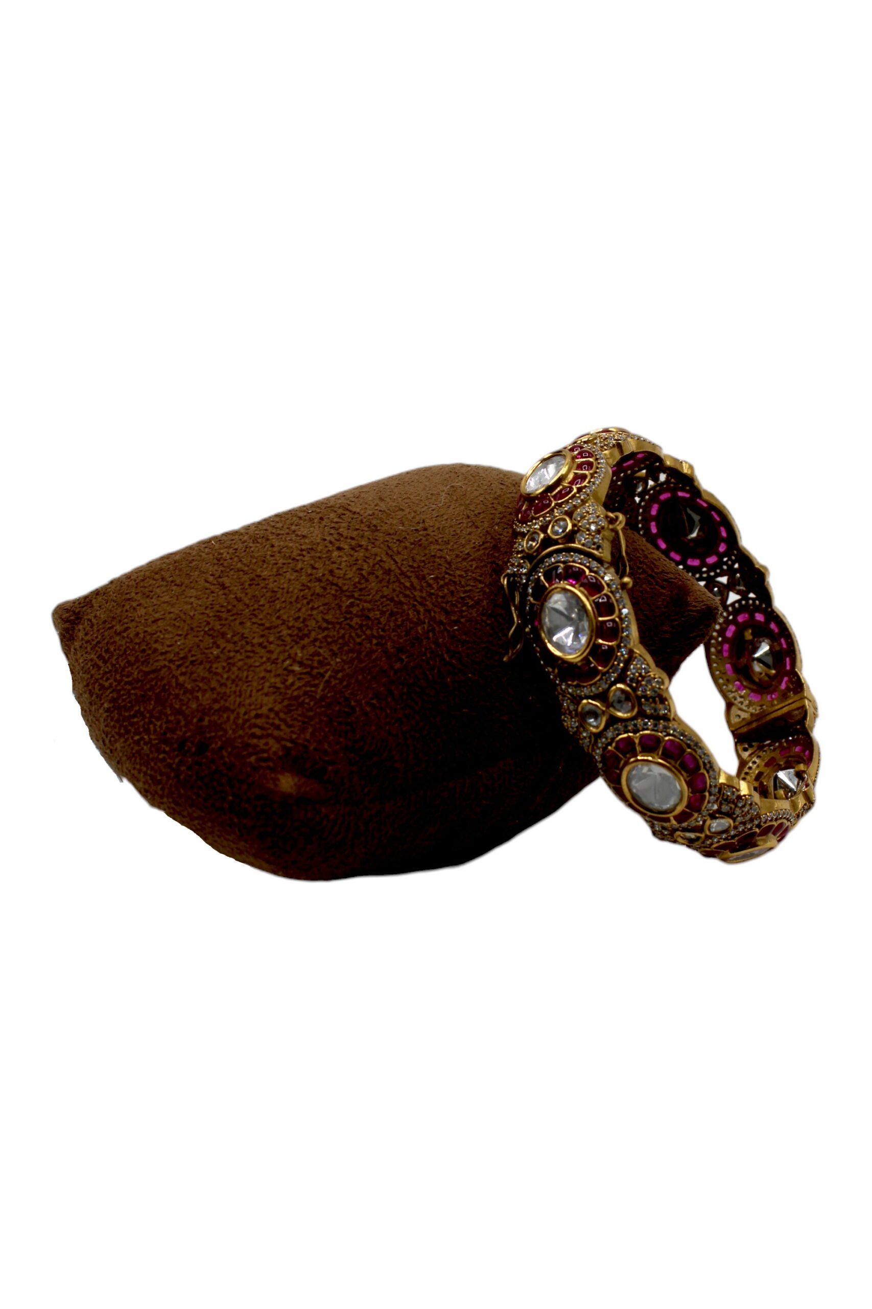 Elegant Gold and Gemstone Bangle on Velvet Cushion