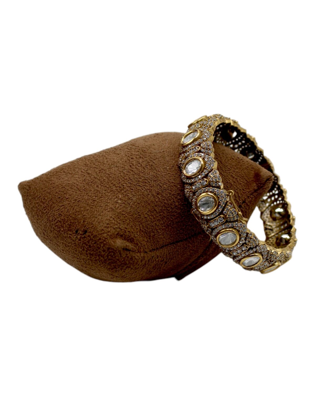 Elegant Gold and Stone-Studded Bangle on Velvet Cushion