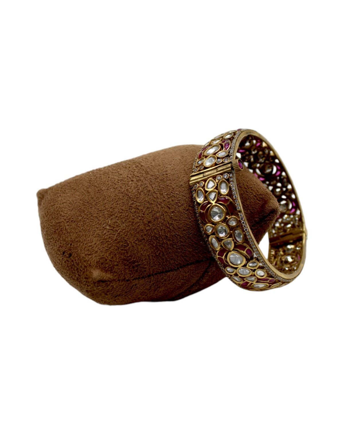 Elegant Gold and Gemstone Bangle on Velvet Cushion